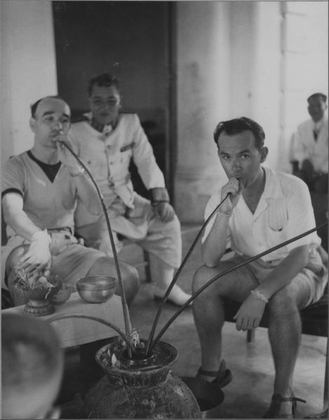 Fête des Eaux : Charles Archaimbault (à droite) et le Dr. Seigneuric buvant à la jarre EFEO_LAO20959
