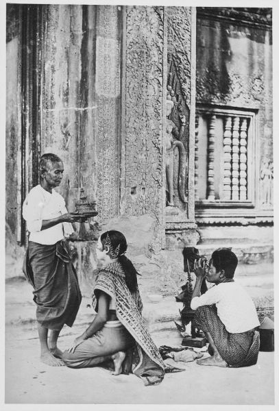 Mise en place du mokot (tiare) d’un personnage féminin secondaire, troupe de danseuses classiques khmères de Siem Reap lors d’une séance de poses à Angkor Vat en 1921
